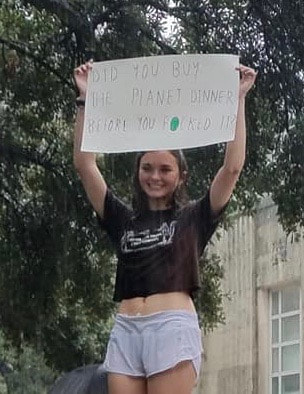 High school student as the Climate Strike rally at Houston's City Hall holding up a pasteboard saying, 