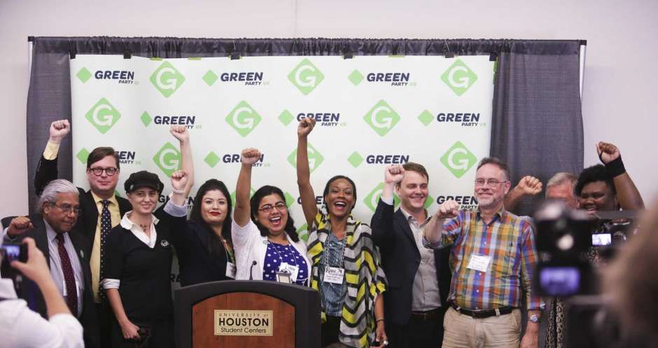 Chronicle photo of ten Green Party candidates with fists raised at a press conference during the Green Party's 2016 national convention at the University of Houston.