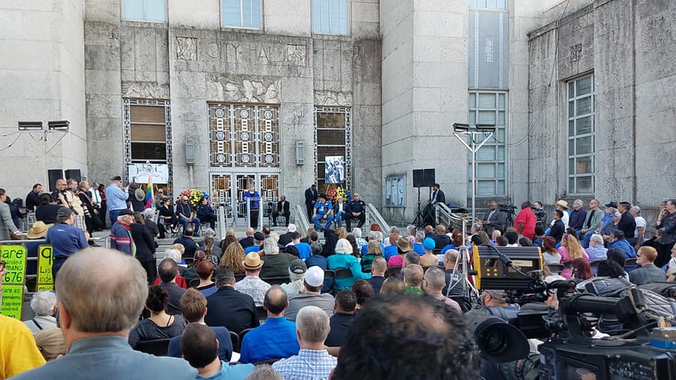 Crowd shot of the Ray Hill remembrance at Houston's City Hall, with former mayor Annise Parker at the lectern.